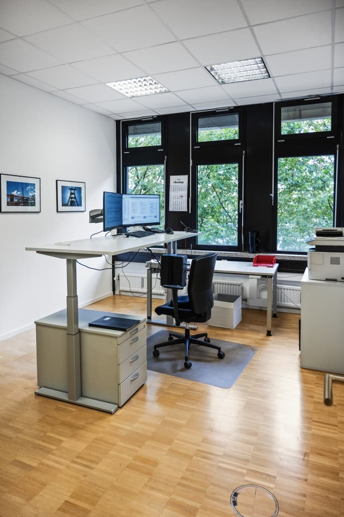 Arbeitsplatz mit höhenverstellbarem Schreibtisch und zwei Bildschirmen